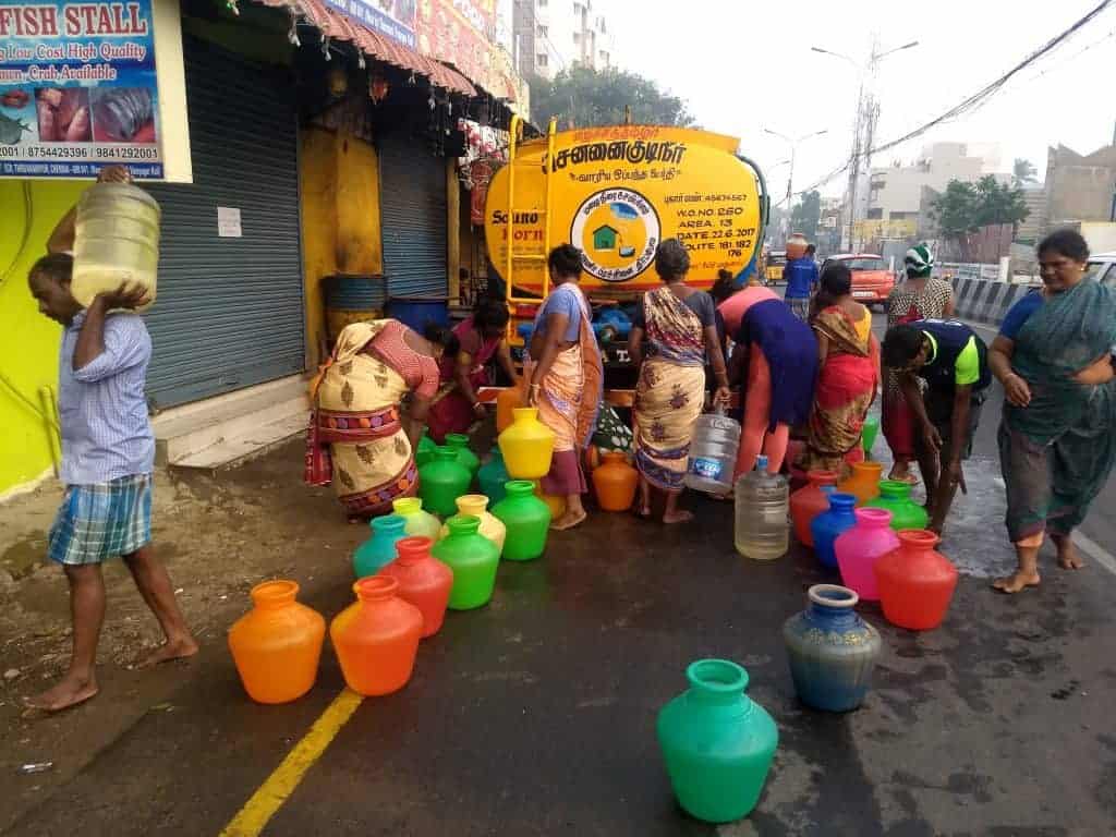 Women queueing up to collect water from a tanker.