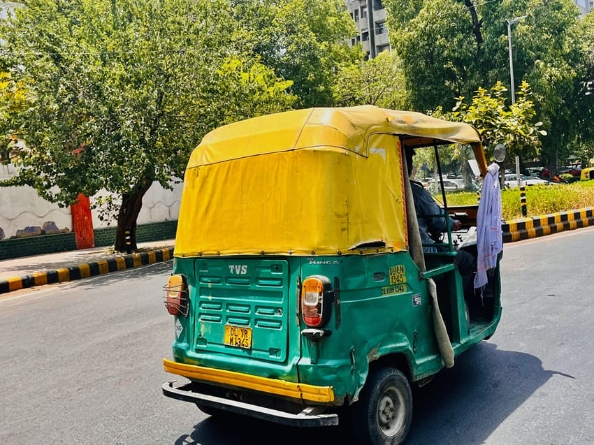 A towel tied to the rearview mirror of an auto which is used to cover face for respite from the heat.