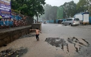 child playing in flooded water in Mumbai