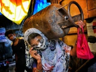 woman carries gas cylinder in Mumbai