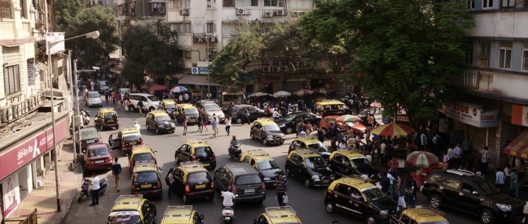 view of a busy street in Mumbai covered with 'kaali peel' taxis