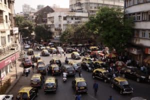 view of a busy street in Mumbai covered with 'kaali peel' taxis