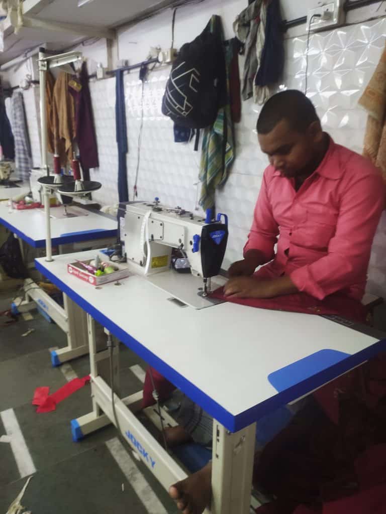 a garment worker in Dharavi working on a sewing machine