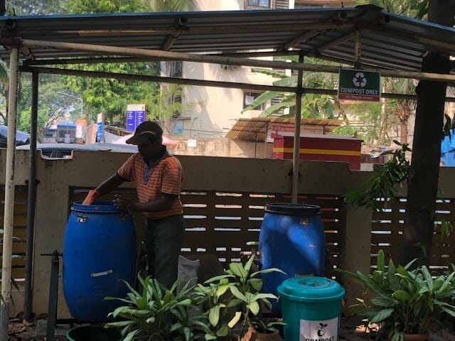 an employee processing compost in the Surabhi building.
