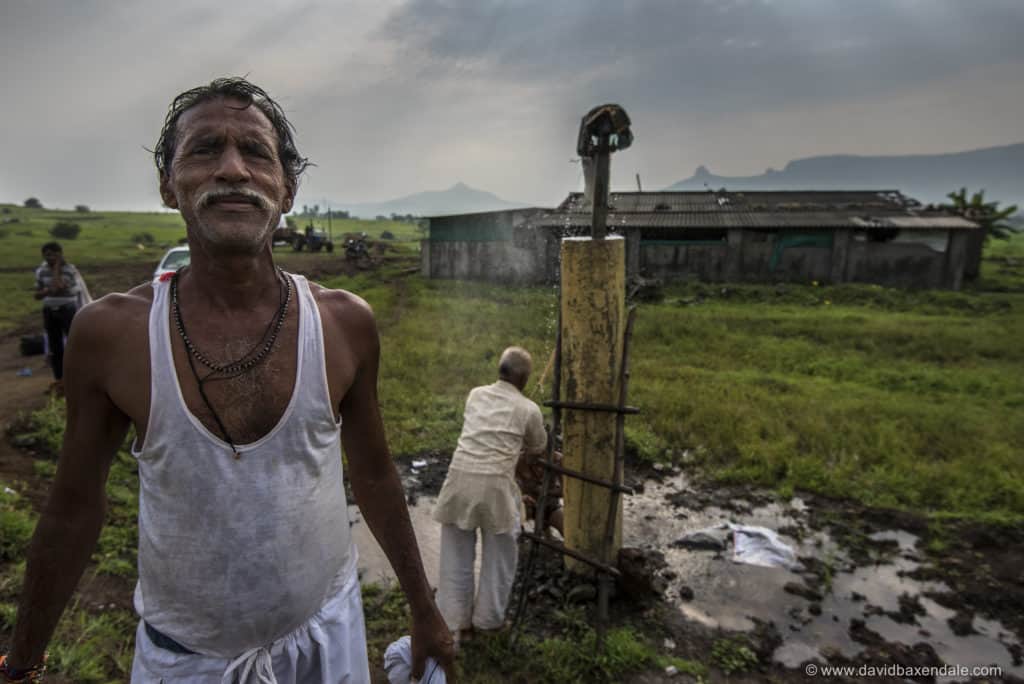 a farmer in Maharashtra faces the camera as he cools down after working on his field